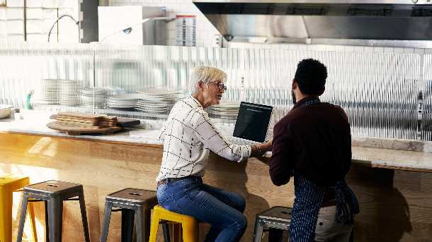 Employer sitting at laptop with employee